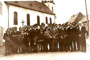 Die Bergmannskapelle im Jubiläumsjahr 1967 Gruppenfoto vor dem Vereinslokal - im Hintergrund die alte Thommer Pfarrkirche